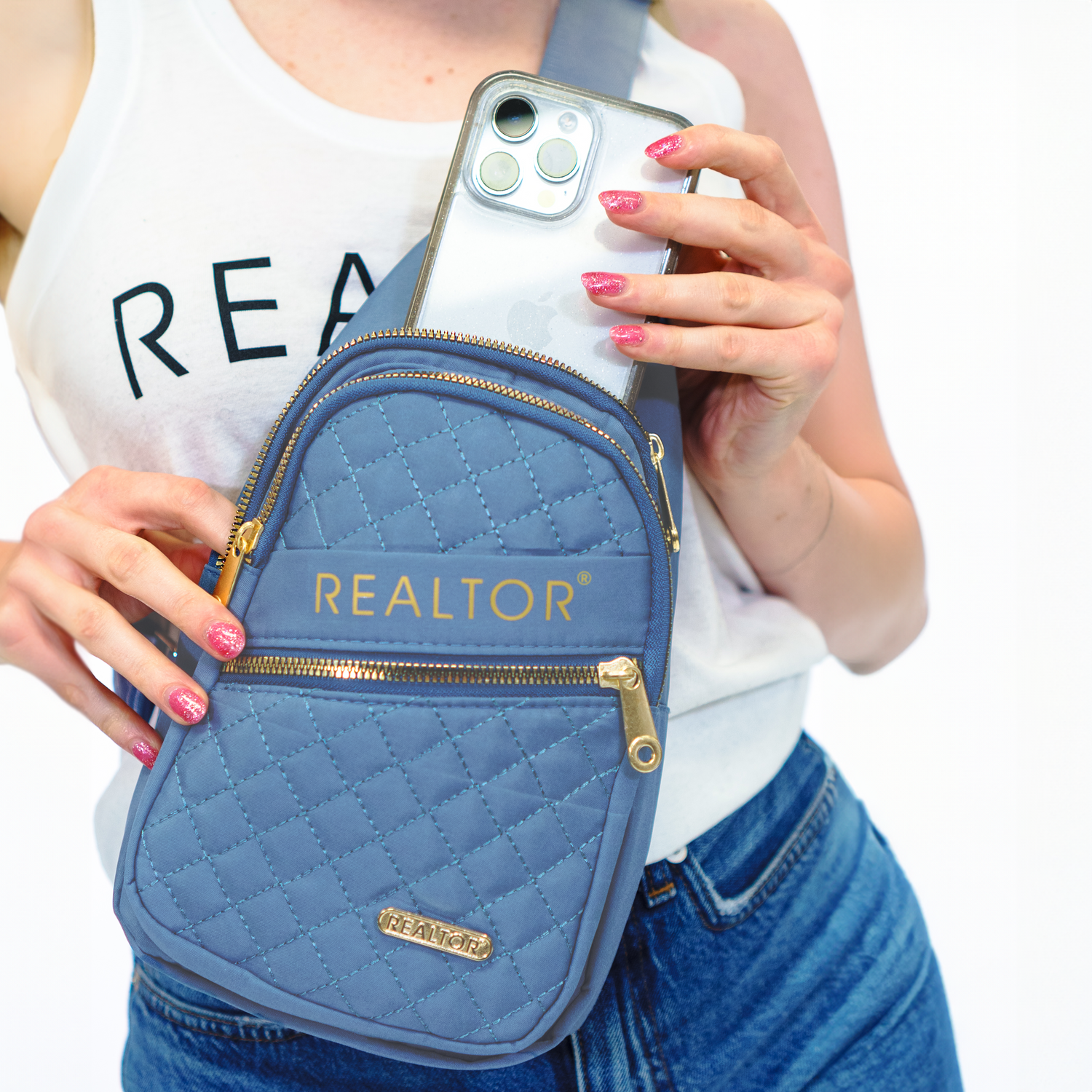 Blue REALTOR® Sling Bag modeled by a woman.